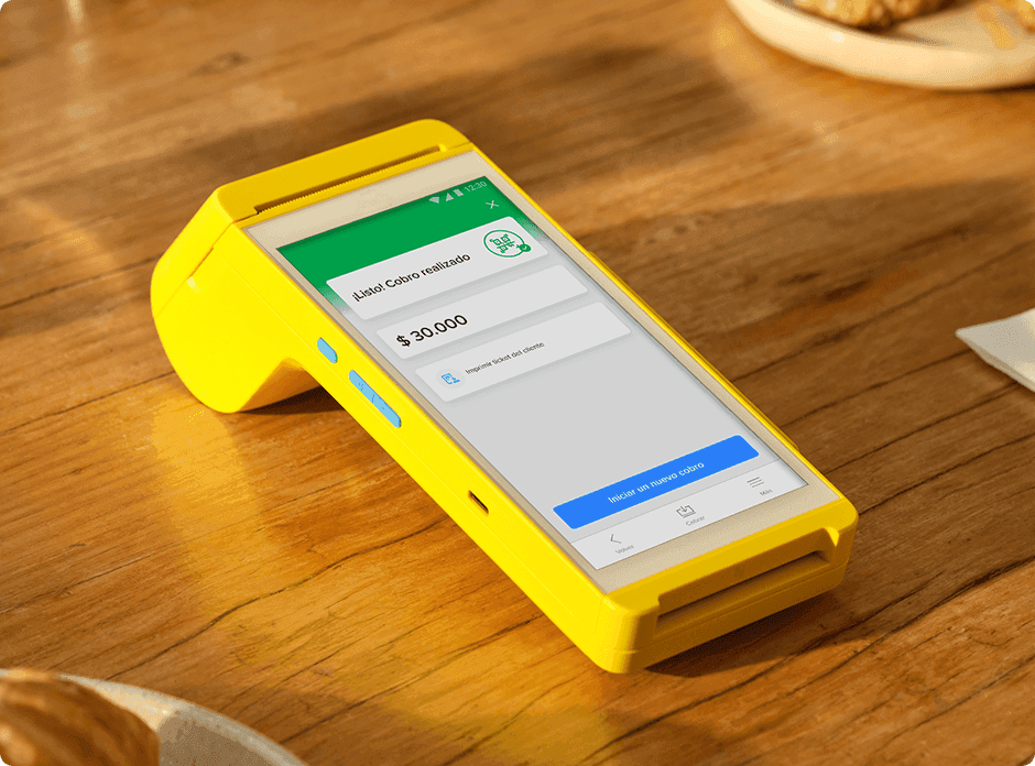 Point Smart 2 de Mercado Pago sobre una mesa de madera, con la pantalla de cobro realizado